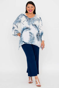 Model in Dorothy top with bell sleeves and navy pants standing on white background