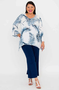 Woman in white and blue palm print top with navy pants, front angled view