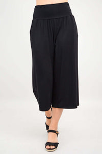 Dynamic angled view of black Gaylene capri pants mid-stride