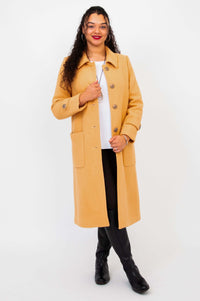 Model with Edna wool blend coat partially unbuttoned, revealing an outfit underneath