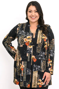 Close-up of a smiling woman in a black and orange floral bamboo tunic with a mandarin collar and V-neckline.