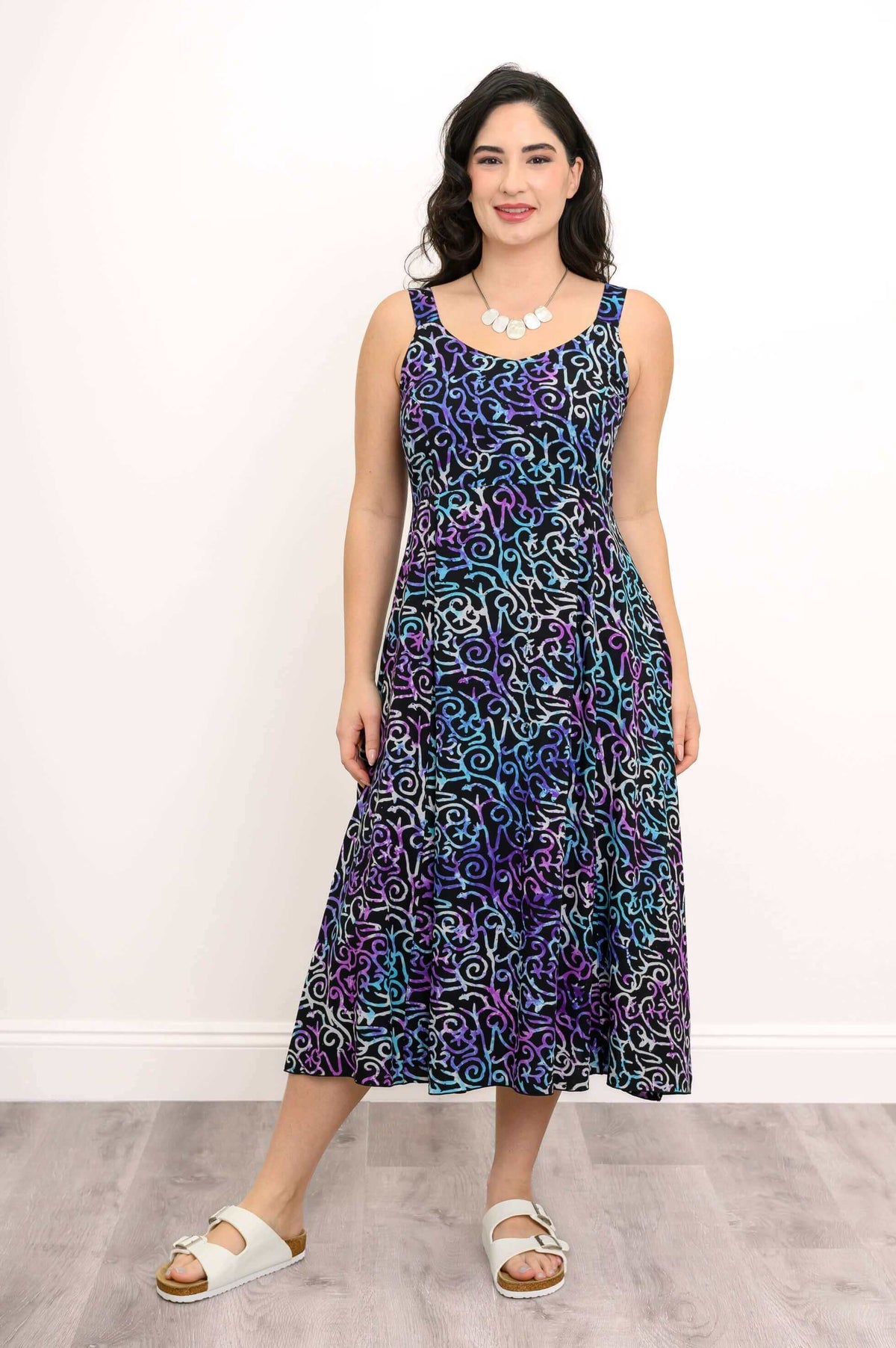 Woman modeling empire waist dress with multicolored abstract swirl print, standing front