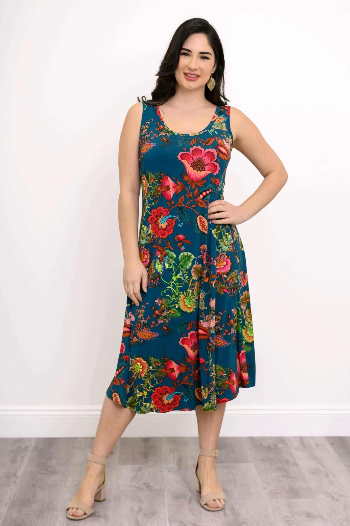 Woman posing with hand on hip in teal floral tank dress, front view
