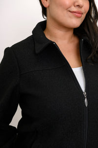 Close-up front view of woman's jacket showing collar, boiled wool texture, and zipper
