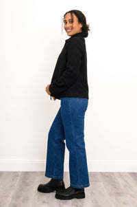 Full body side view of woman in wool carpenter style jacket paired with straight-leg jeans
