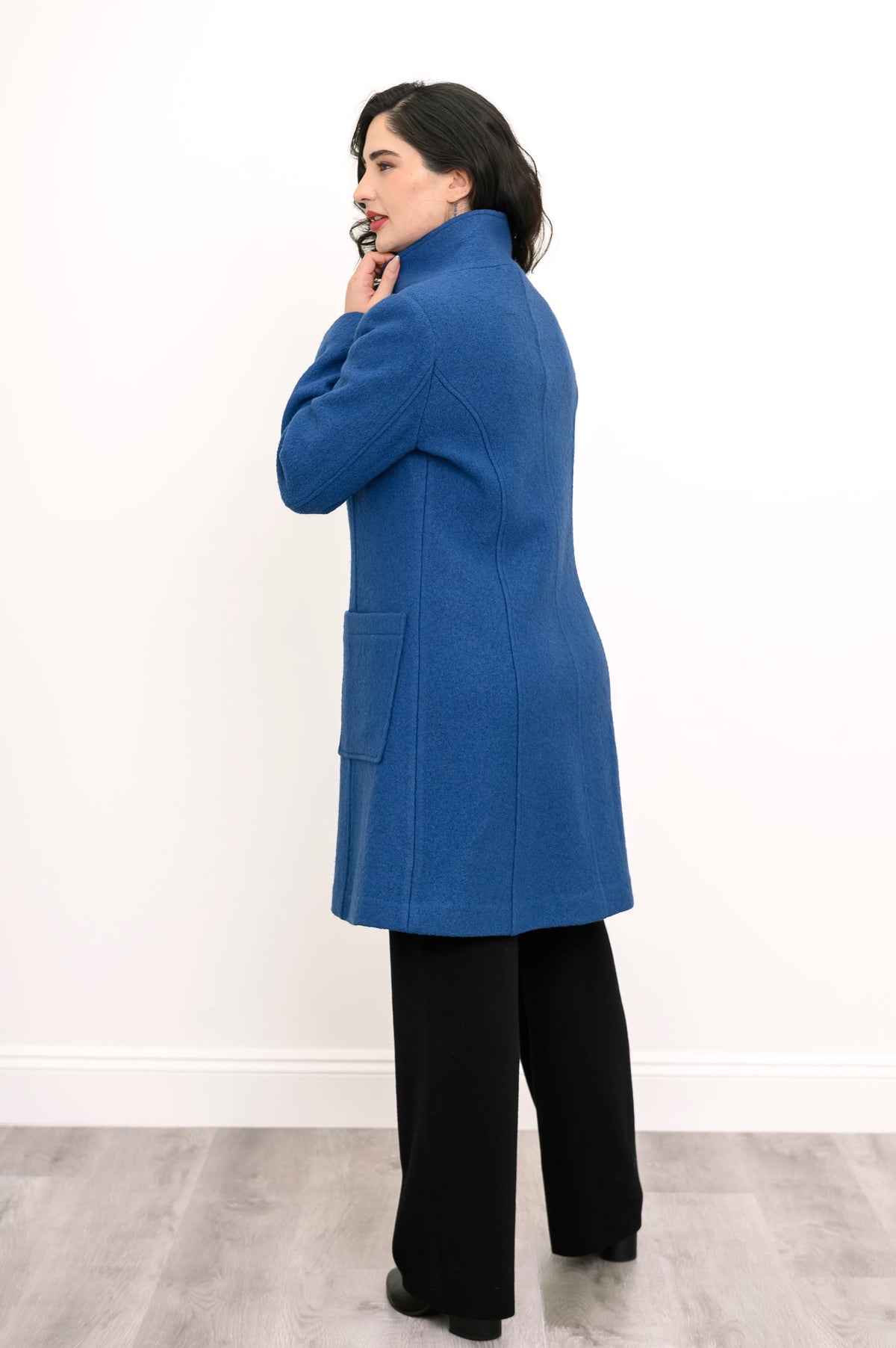 Back view of woman modelling long coat with pockets in cobalt blue boiled wool fabric