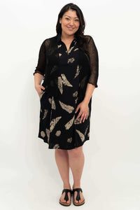 Woman wearing black dress with tan feather print styled with a sheer black cardigan
