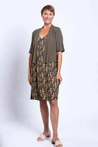 Woman in Felicia dress styled with green short-sleeve cardigan