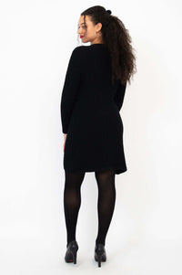 Back view of woman in a fitted black cable knit sweater dress