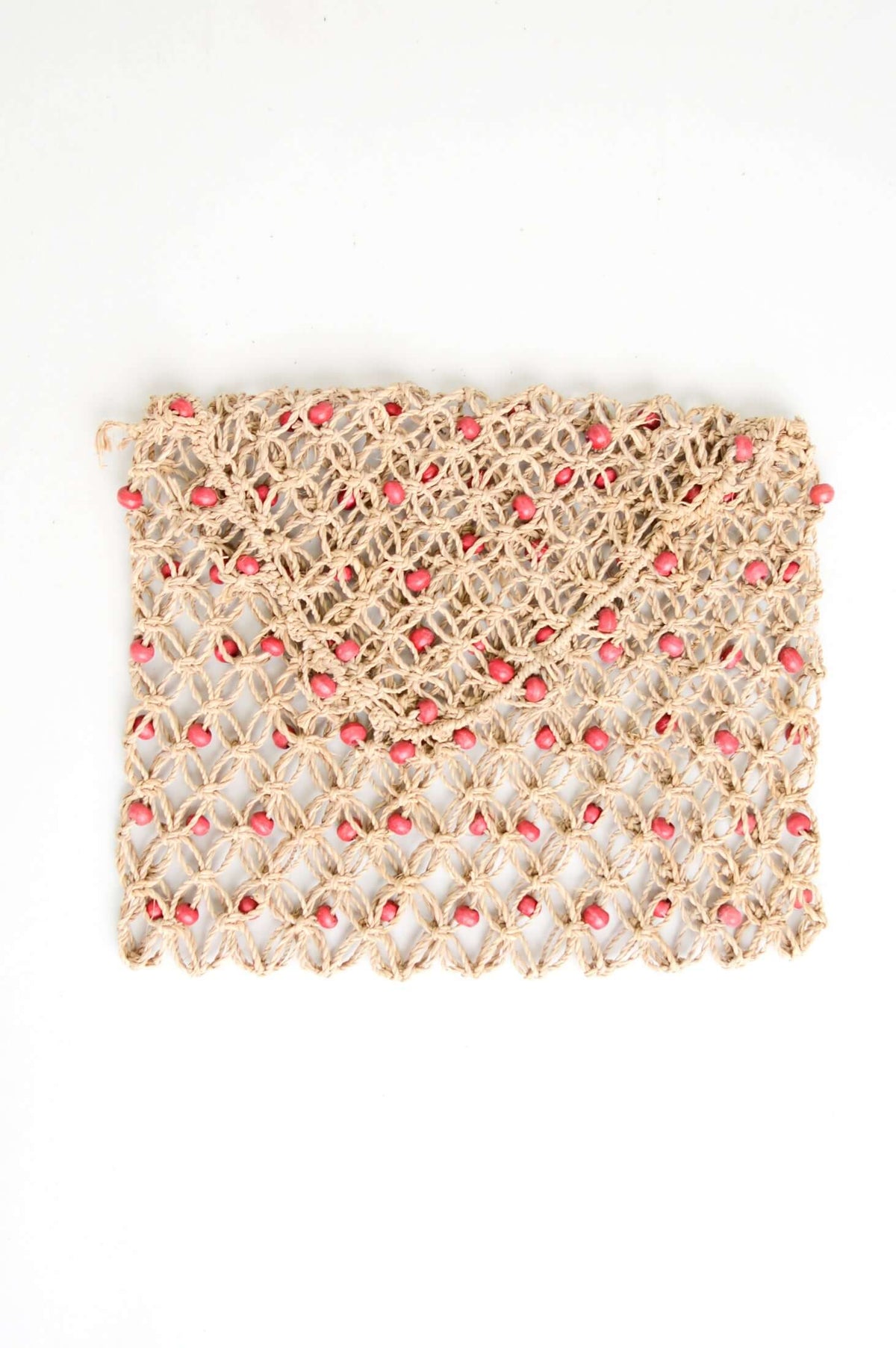 Flat handwoven rattan purse with coral beads on a white background