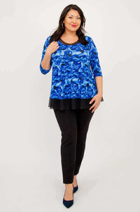 Woman walking forward in the Flora Top in Blue Rose, styled with black pants and heels