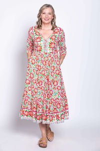 Model with hands in pockets showcasing floral batik midi dress