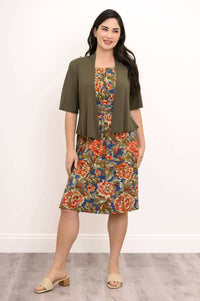 Model wearing a floral dress paired with an olive green open jacket