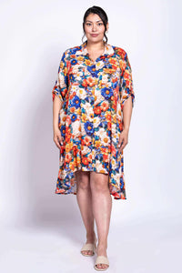 Model standing in a vivid floral dress with shirt collar and button-up front