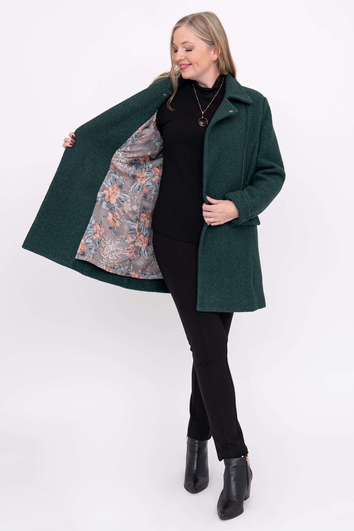 Woman showing floral printed lining of a dark green wool coat