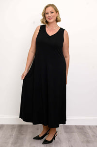 Woman modeling a flowing black maxi dress, holding out the skirt slightly
