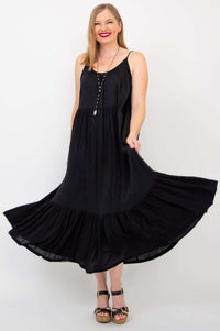 Woman twirling in a black tiered maxi dress showing the airy, flowy design