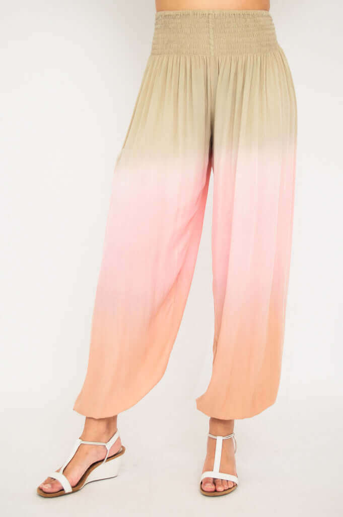 Flowy high-waisted ombre pants displayed from the front, gradient beige to pink to peach