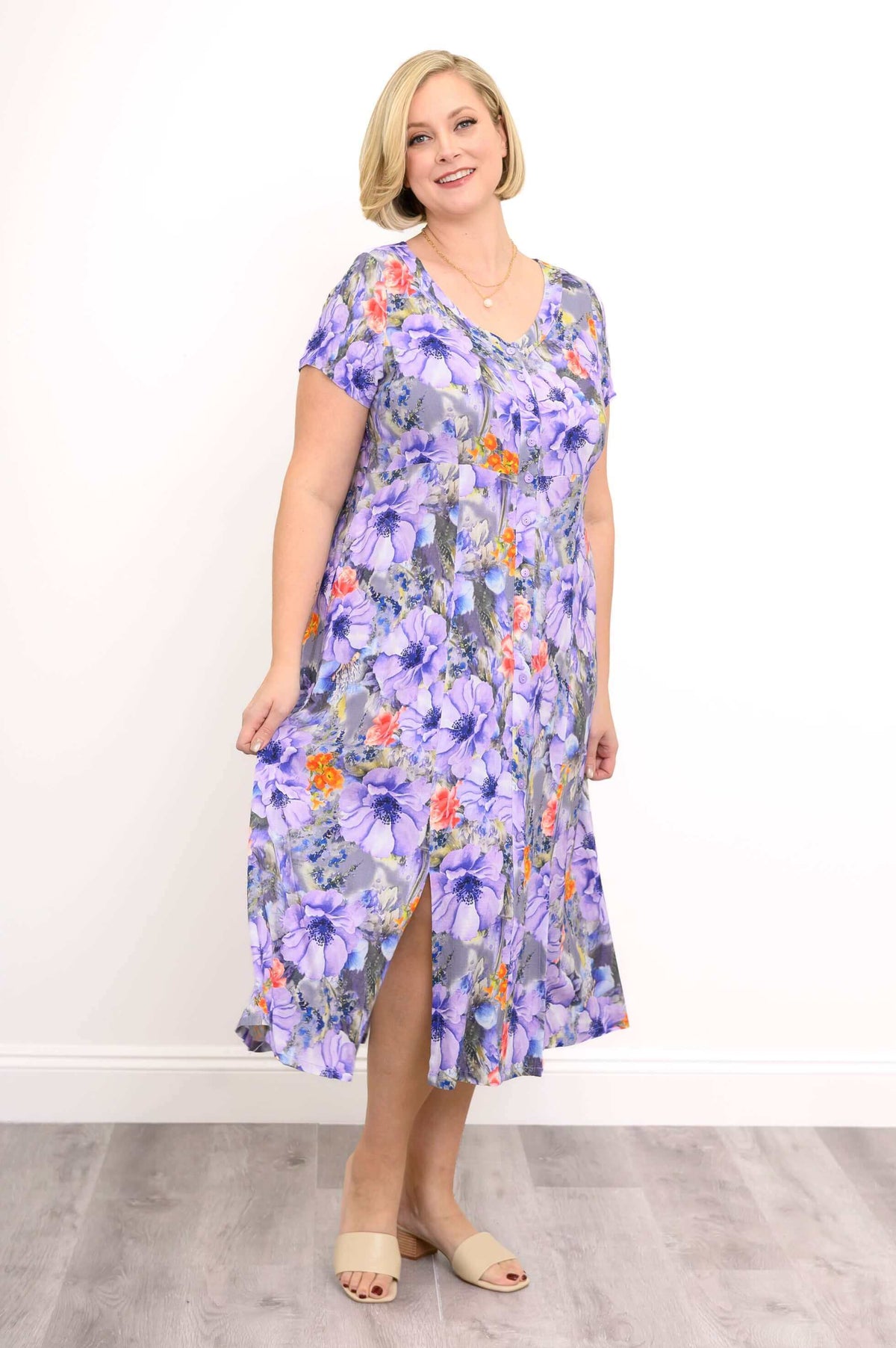 Front view of woman modelling short sleeve purple and orange maxi dress with slit detail