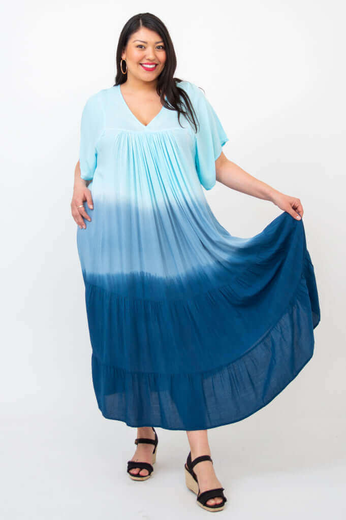 Woman in blue ombre maxi dress holding out skirt to show flowy tiers