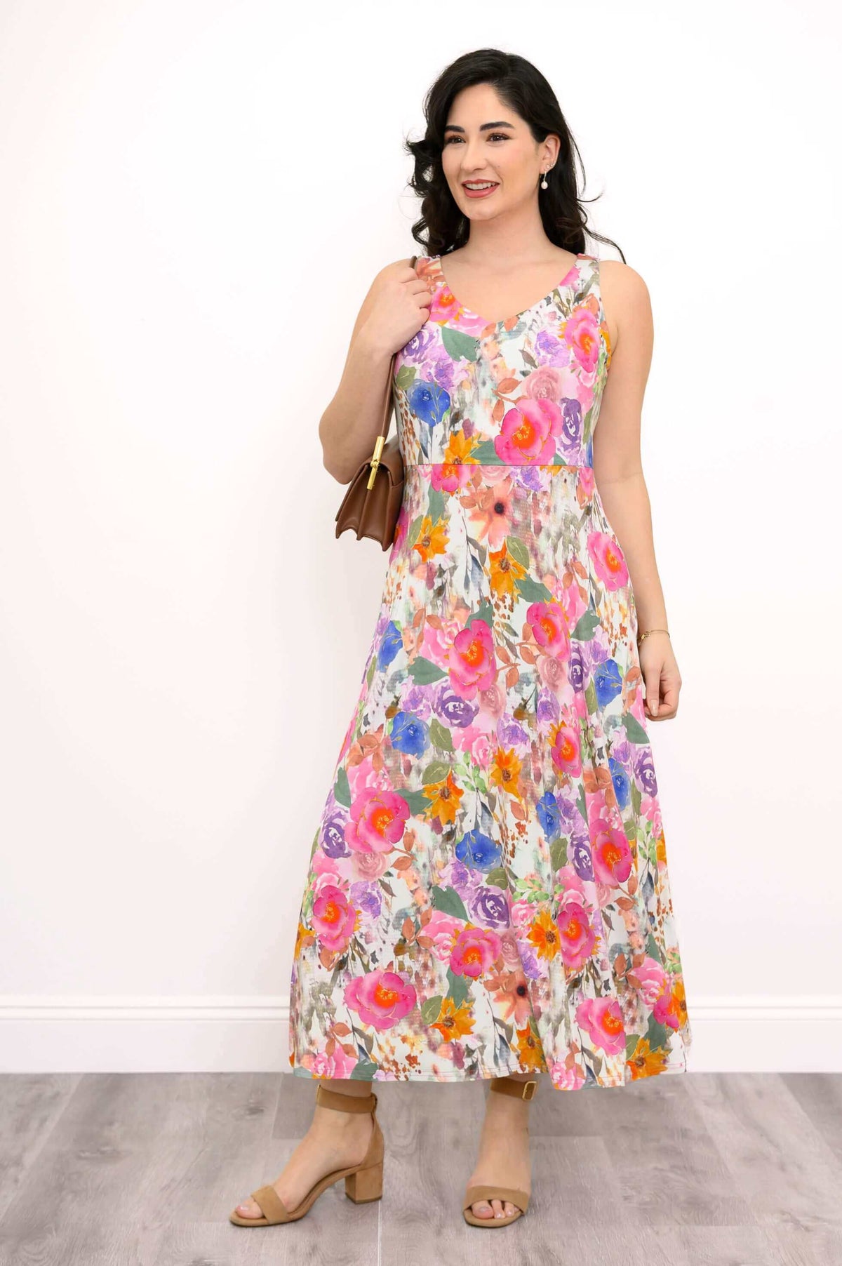 Front angled view of a woman in a vibrant sleeveless floral bamboo dress