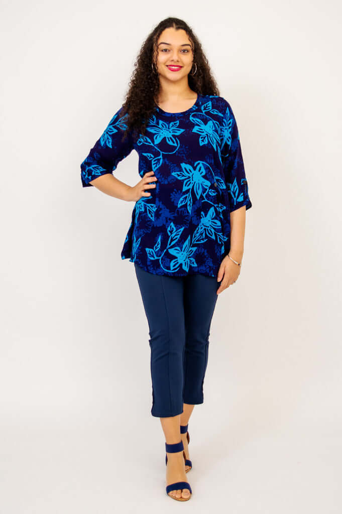Woman facing forward wearing the Palace Blouse in blue floral with hands on hips