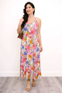 Front view of a woman wearing a sleeveless floral maxi dress and tan sandals