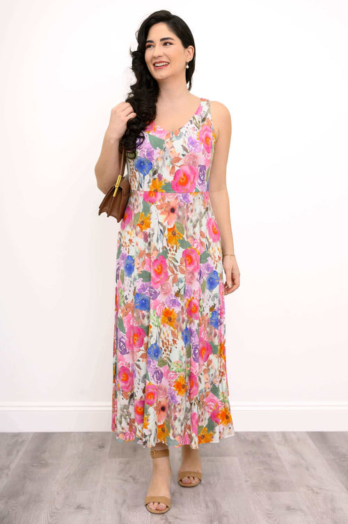 Front view of a woman wearing a sleeveless floral maxi dress and tan sandals