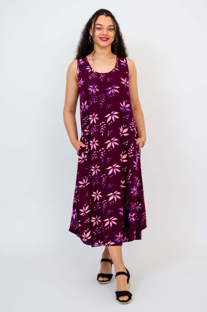 Front view of a woman in a purple floral swing midi dress with rounded hem