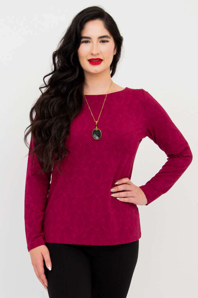 Woman modeling a berry-colored long sleeve top with black pants, front angled view