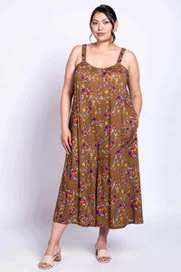 Person wearing a brown floral jumpsuit with wide hem and elastic straps, front angle