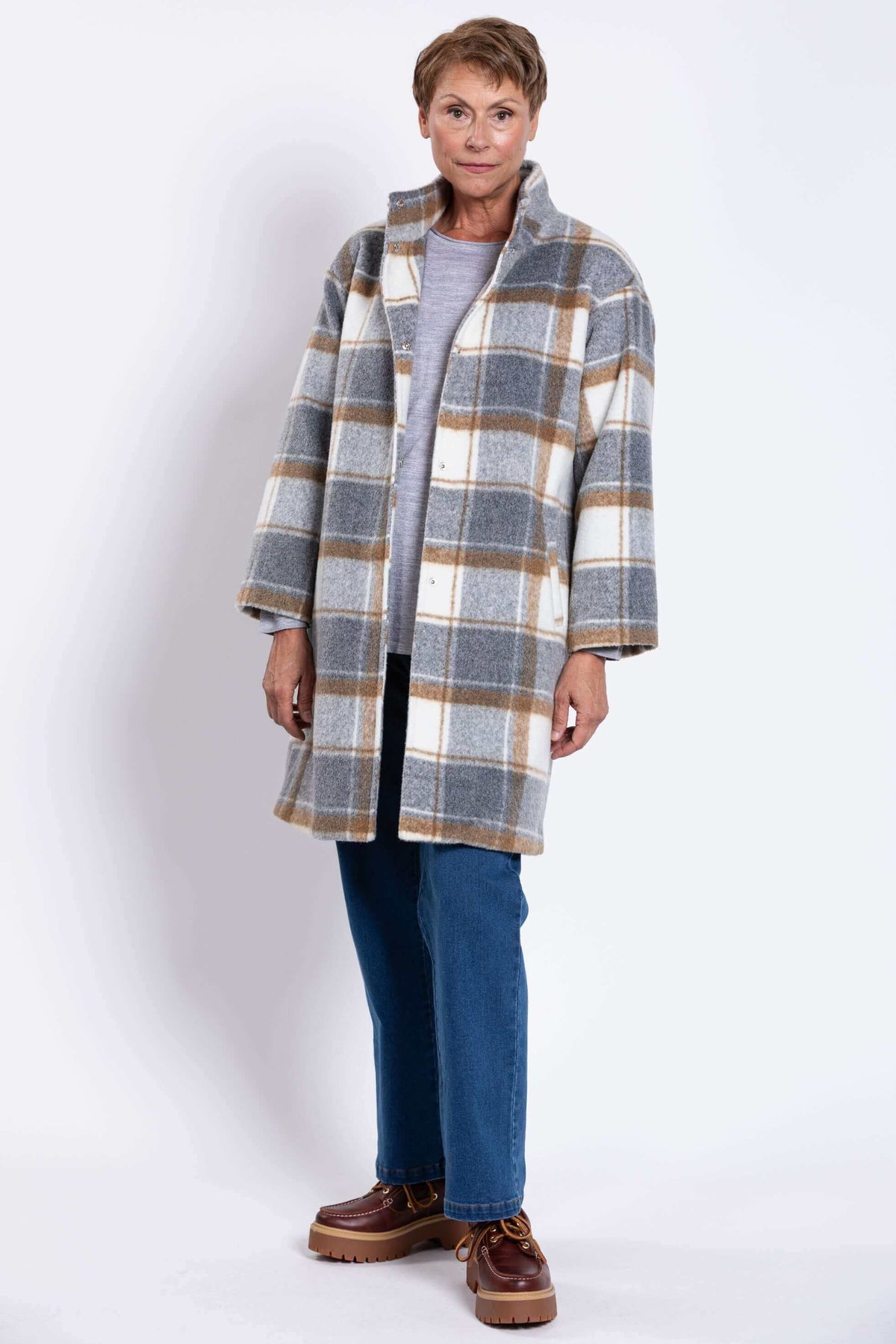 Front angled view of woman modeling plaid wool coat