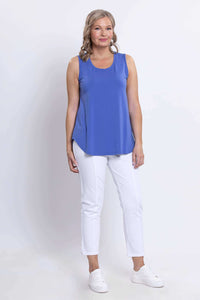Front angled view of woman modelling round neck blue tank and white capri pants