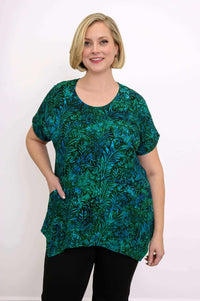 Close-up front view of woman wearing green and blue leafy print tunic top with round neckline