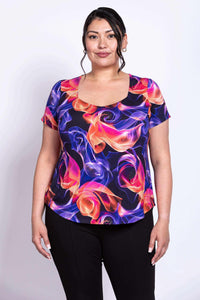 Front close-up of model wearing Ritzy Short Sleeve Top with vibrant swirl pattern