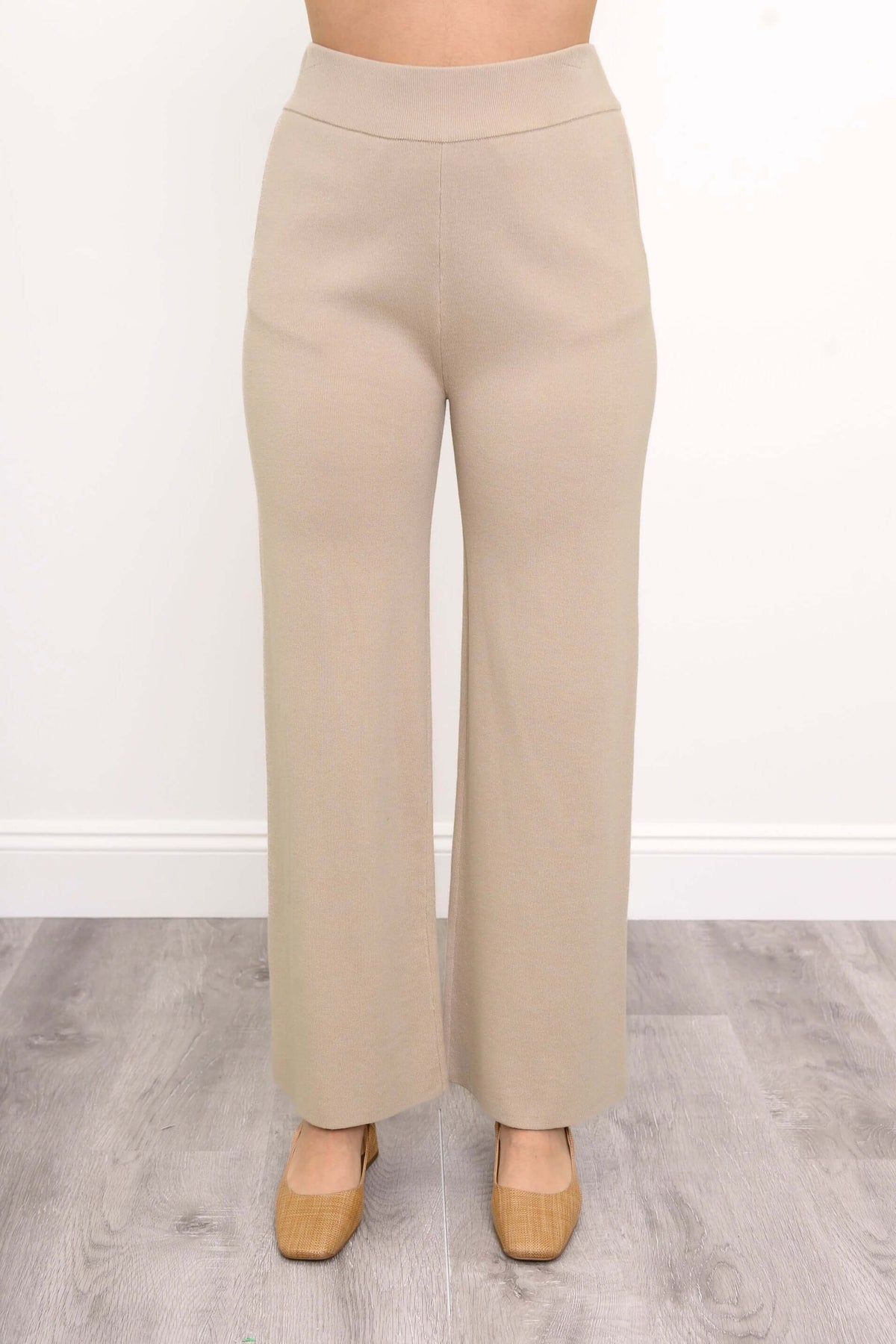 Front view close-up of beige Bailey transitional track pants on a person