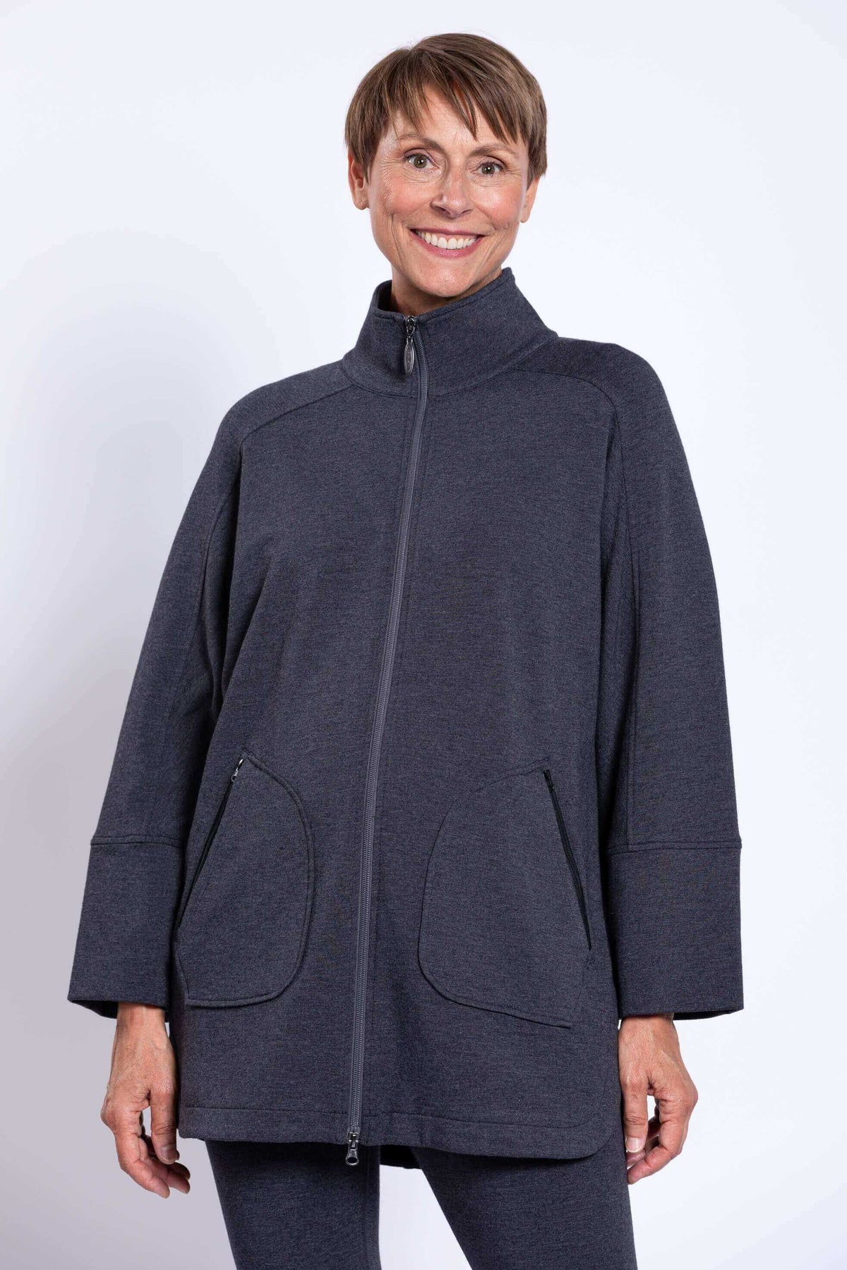Front close-up showing high collar zipped up on a dark grey jacket