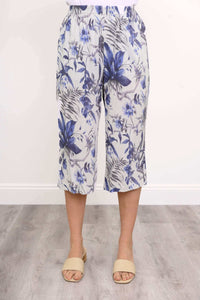 Front close-up of blue floral capri pants with elastic waistband styled with cream sandals