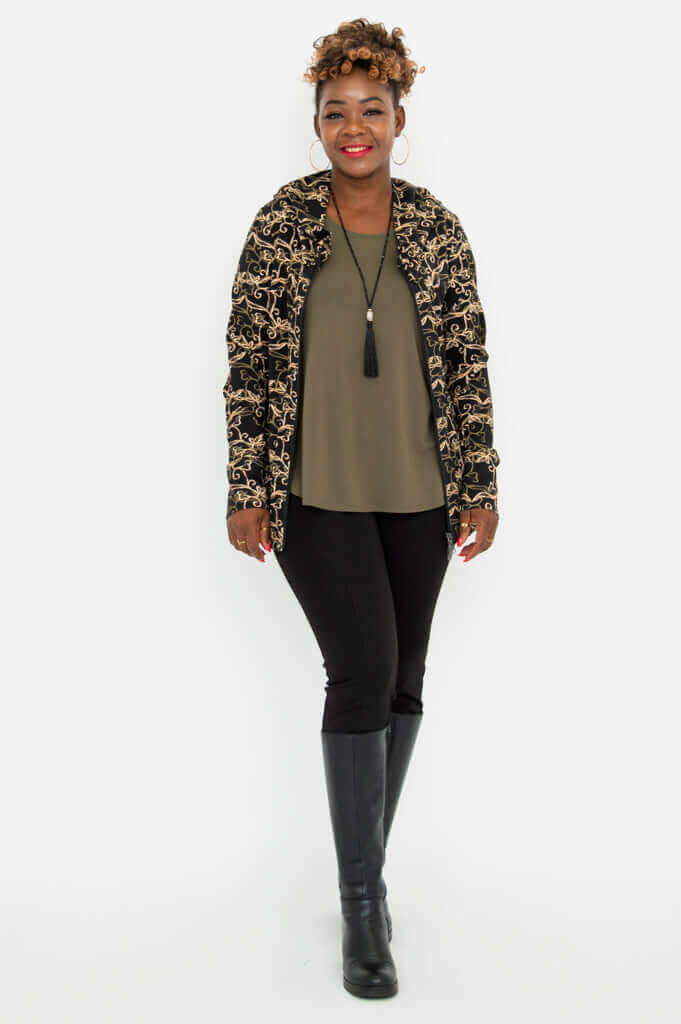 Woman standing front-facing in unzipped vine print jacket over an olive top