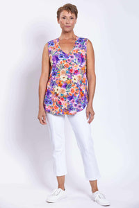 Front full-length view of a floral sleeveless bamboo top worn with white pants