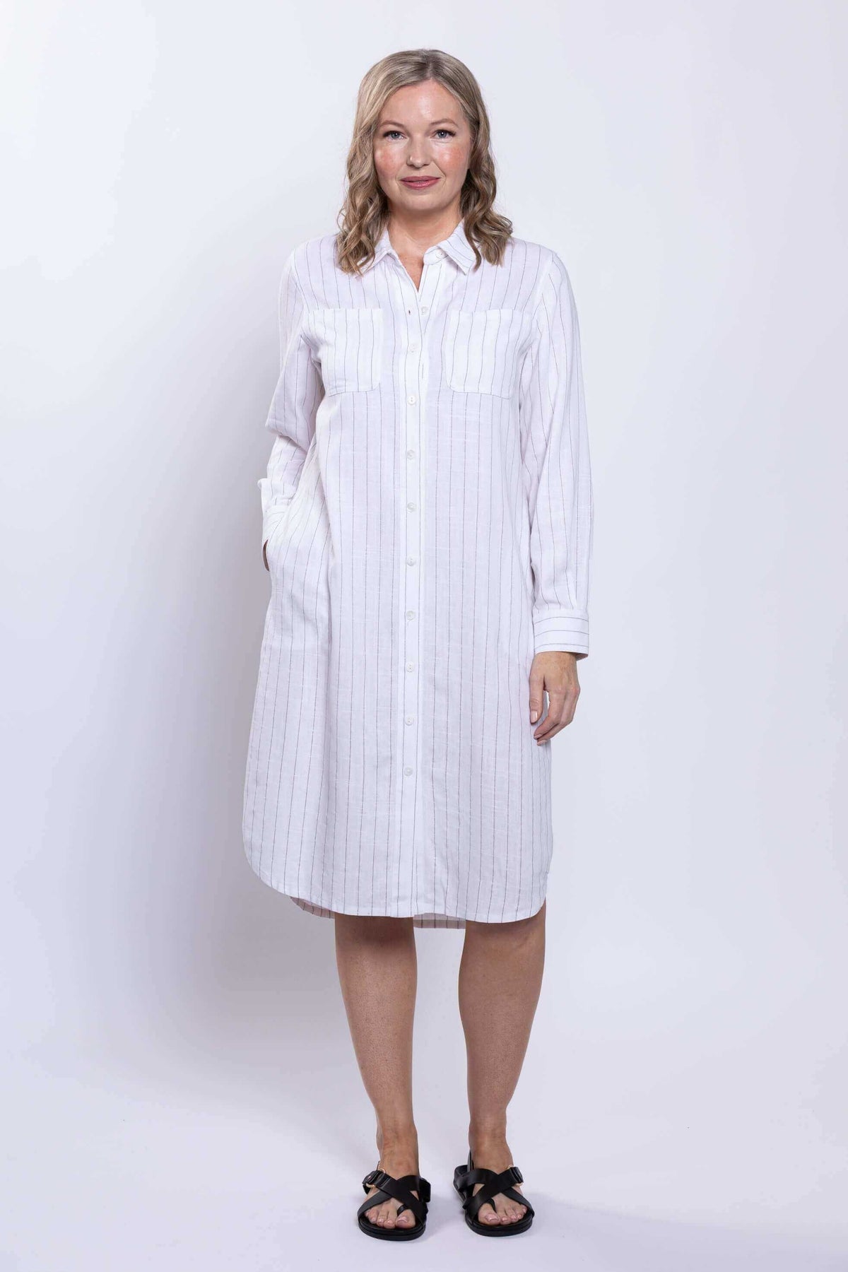 Model facing forward, hands in pockets, wearing viscose linen duster dress