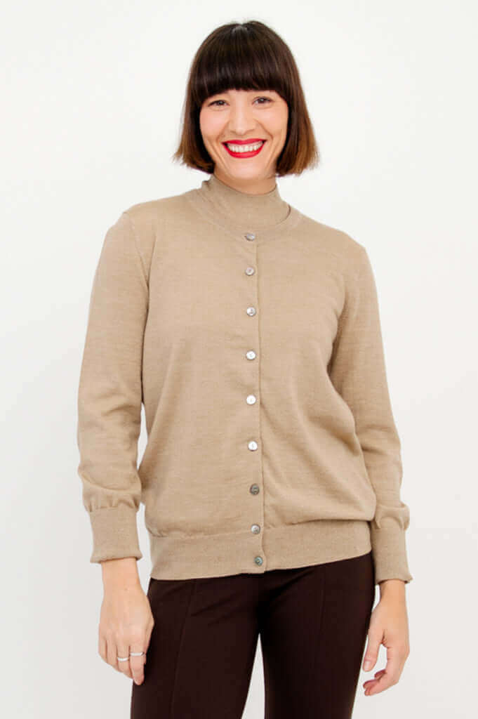Front view of a woman wearing a beige merino wool button-up cardigan