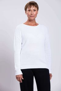 Front portrait of a model wearing a white cotton shaker stitch sweater