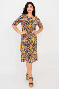 Front pose of woman in Olivia Tropikal print dress, one hand on hip, mid-length sleeves
