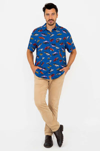 Man standing with arms in pockets wearing blue monster truck print shirt