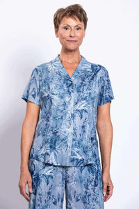 Front pose of woman in blue floral print shirt and matching bottoms, short sleeves and buttons