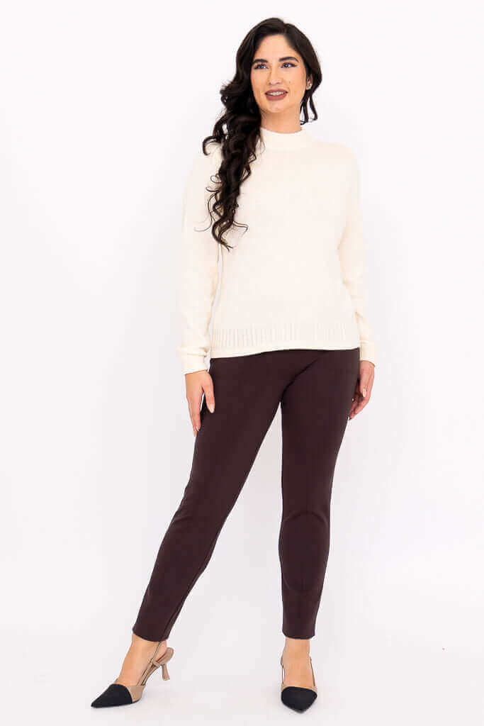 Woman in ivory sweater and brown pants, full body front pose with long wavy hair