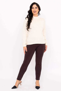 Woman in ivory sweater and brown pants, full body front pose with long wavy hair