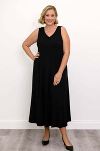 Woman posing in a black ruched V-neck maxi dress, hand on hip, smiling