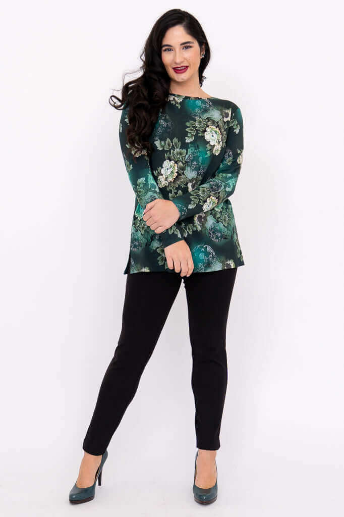 Woman posing in a green floral boat neck top with arms crossed, full body front